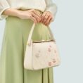 model-holding-plum-blossom-bag-both-hands-front.jpg